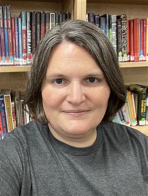 Picture of Mrs. Rysewyk in front of book shelves