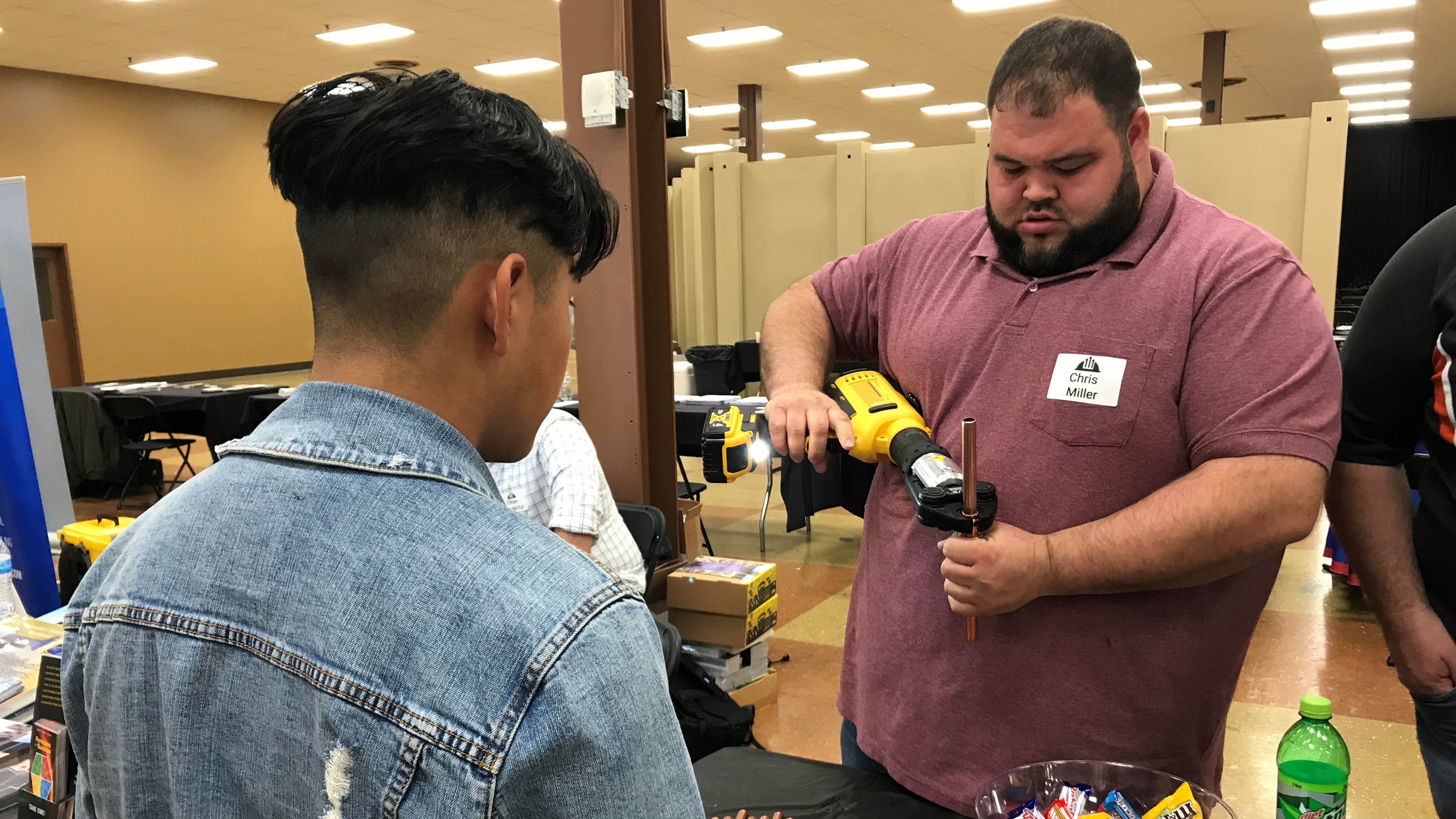 Chris Miller, of HVAC contractor United Services, Inc., demonstrates equipment used by the company during the CTEP career fair. 