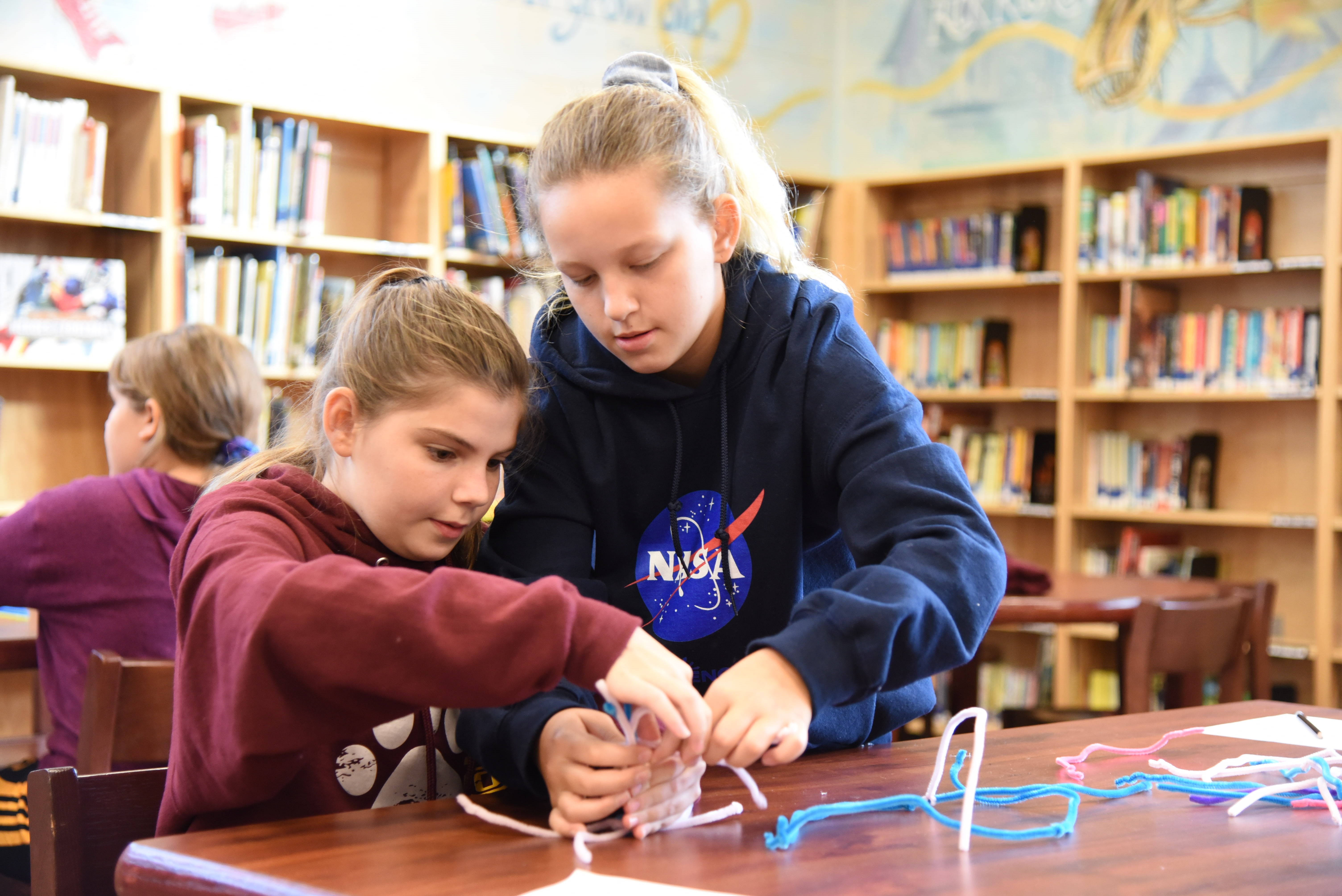 Students at Gear Up 4 STEM camp work on a project to design a free-standing structure out of pipe cleaners. 