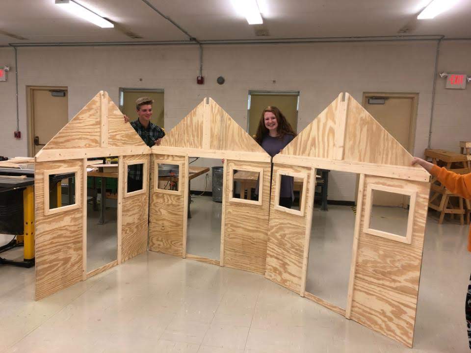 Gibbs High School students Logan Holland and Hadley Parker pose with components of a playhouse their class is building in connection with Habitat For Humanity. 