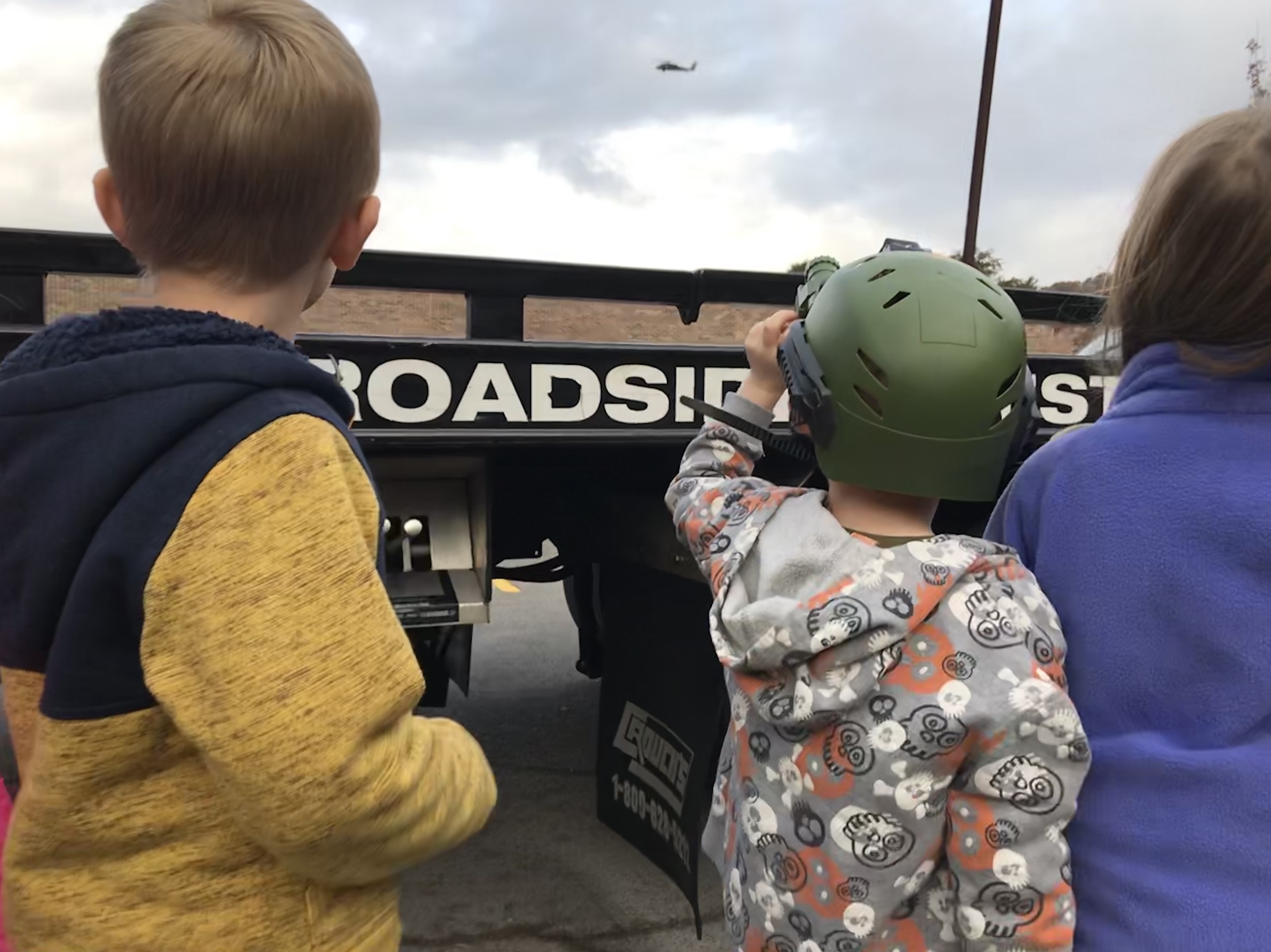 A student at East Knox County Elementary School uses a toy scope to watch as a National Guard helicopter lands at the school for Career Day. 
