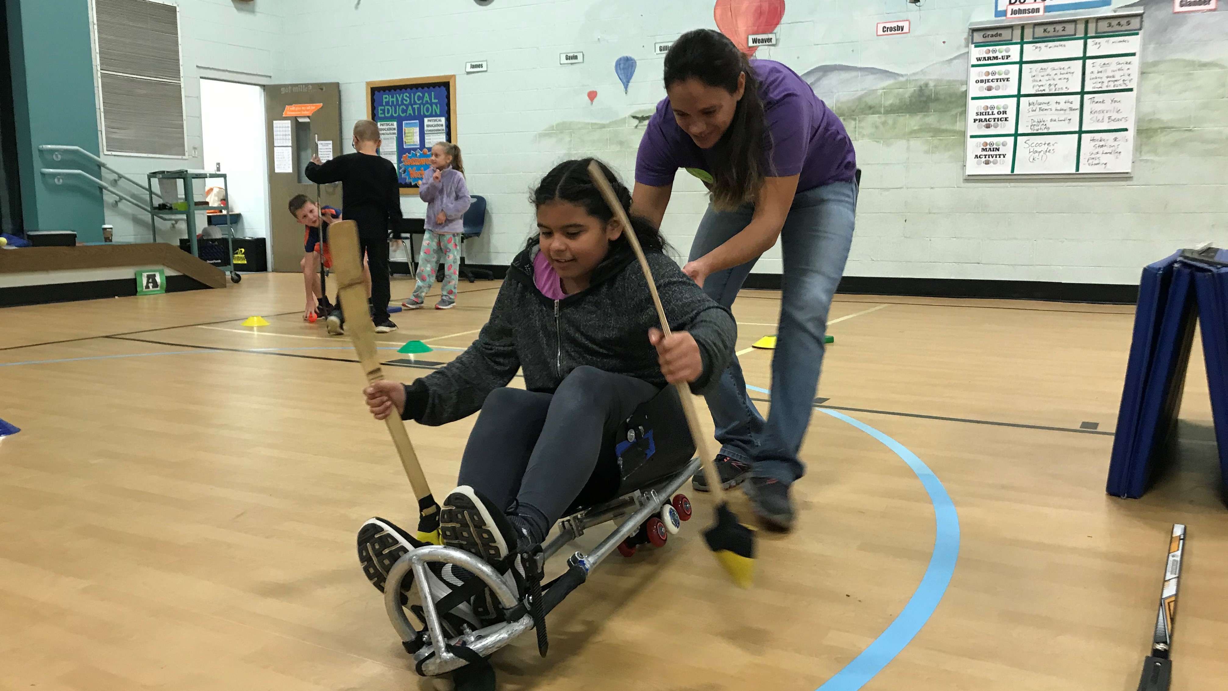Kristin LeBlanc, director of the Knoxville Sled Bears, helps a Ritta Elementary student maneuver on a modified hockey sled. 