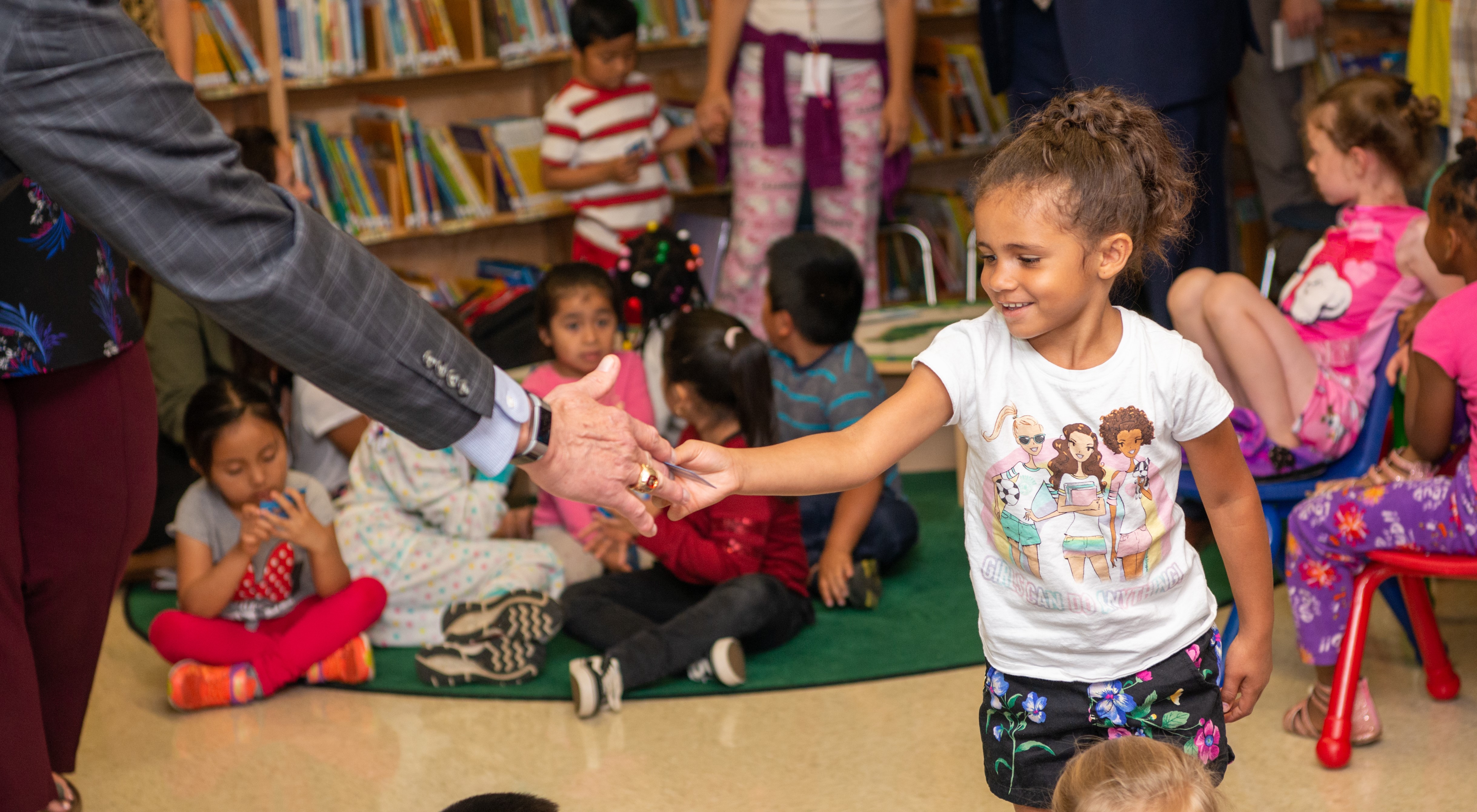 KCS Superintendent Bob Thomas hands a library card to a Sam E. Hill Primary School student.
 