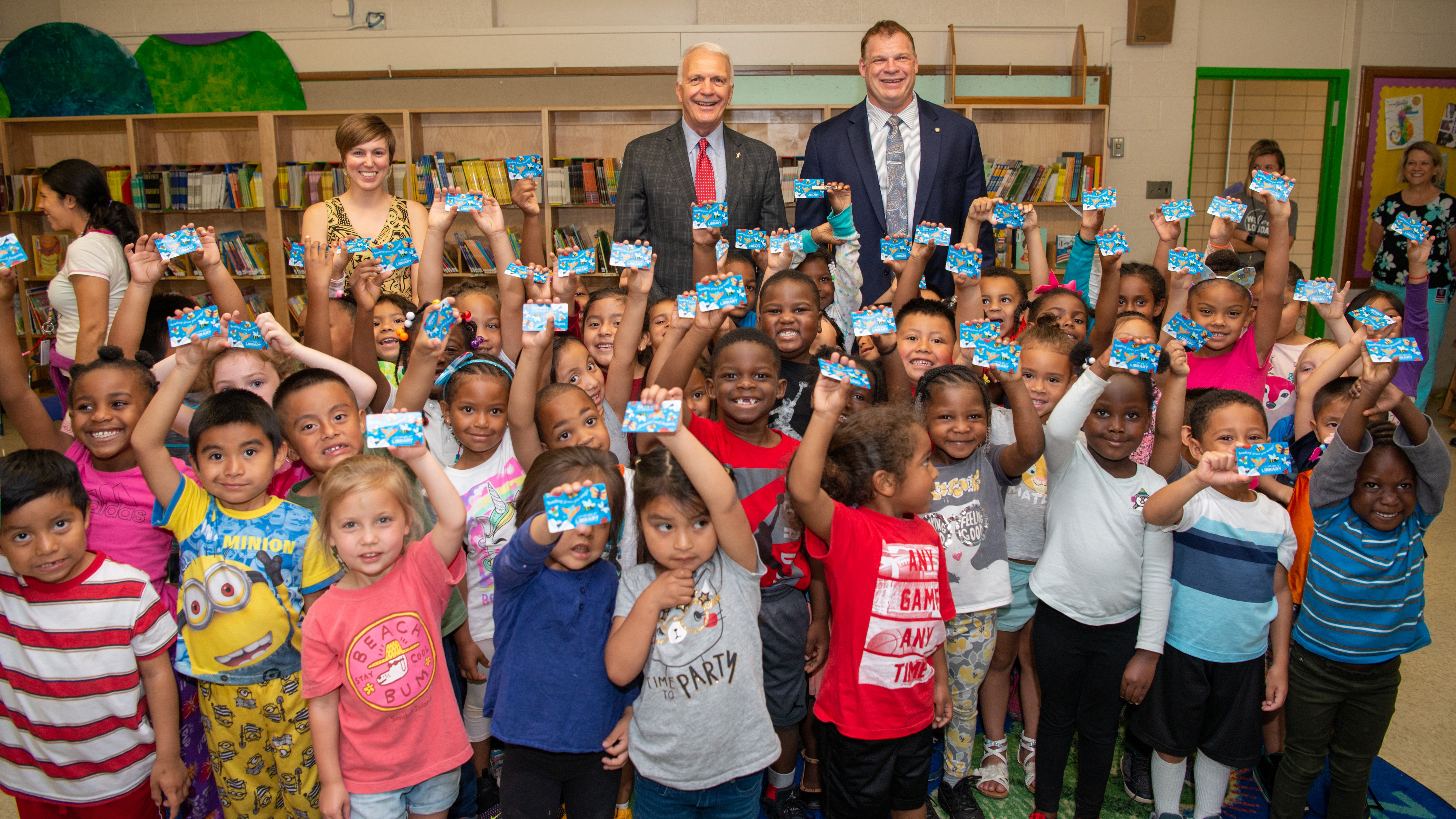 Sam E. Hill Librarian Rachael Nichols, Superintendent Bob Thomas and County Mayor Glenn Jacobs celebrate with students who received library cards.. 