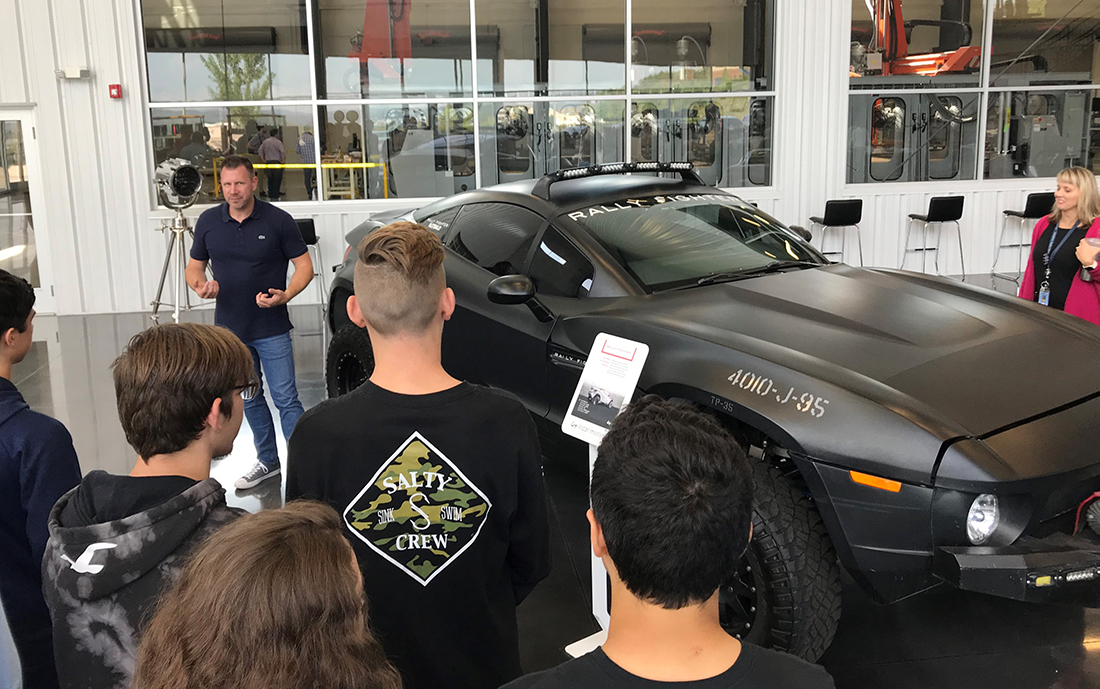 Students from Hardin Valley Academy look on as Gregory Haye, general manager of the Local Motors Knoxville micro-factory, talks about the company's Rally Fighter off-road vehicle. 