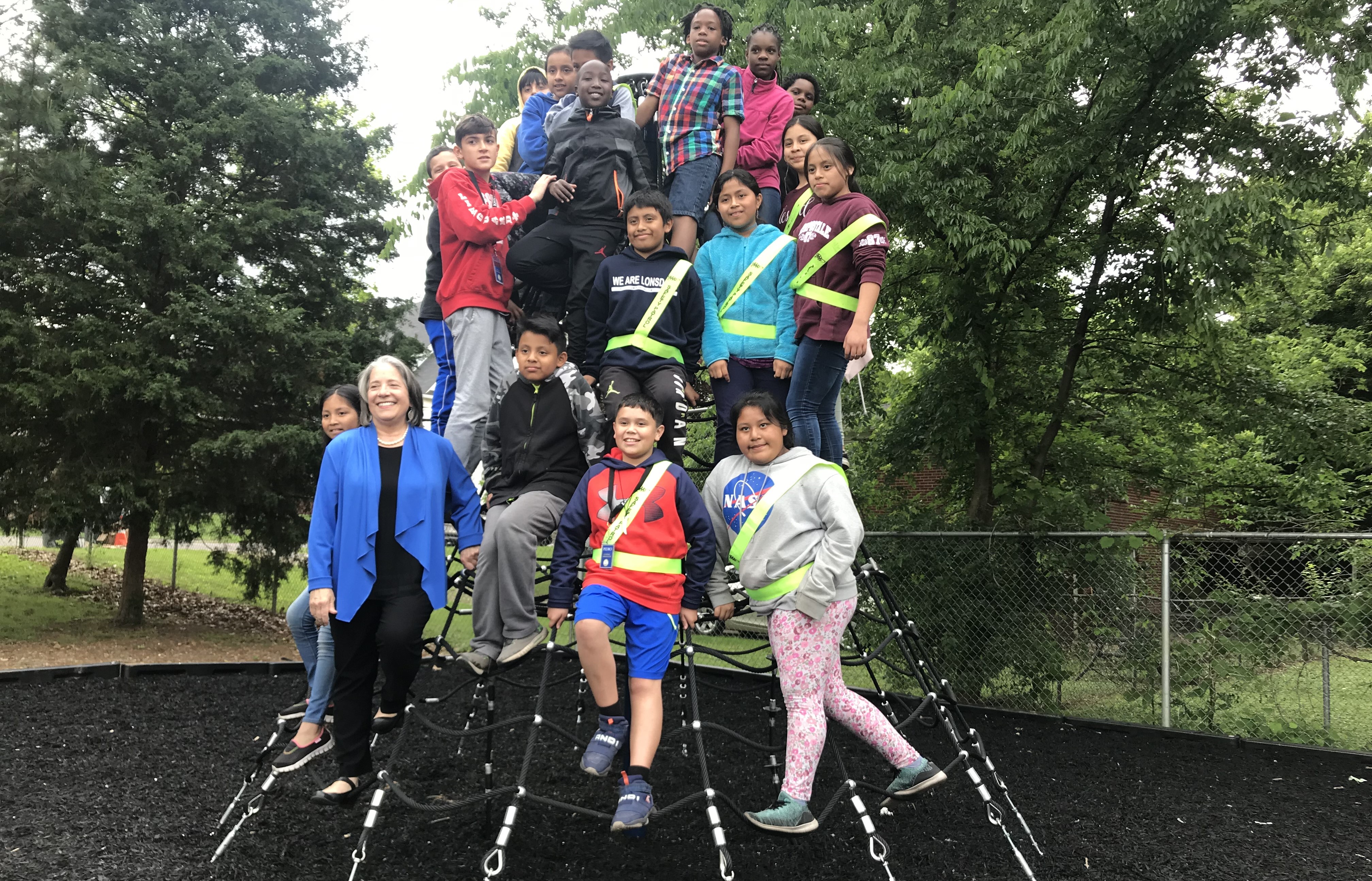 Knoxville Mayor Madeline Rogero poses with Lonsdale Elementary students on a new net climber that was recently installed at the school's playground. 