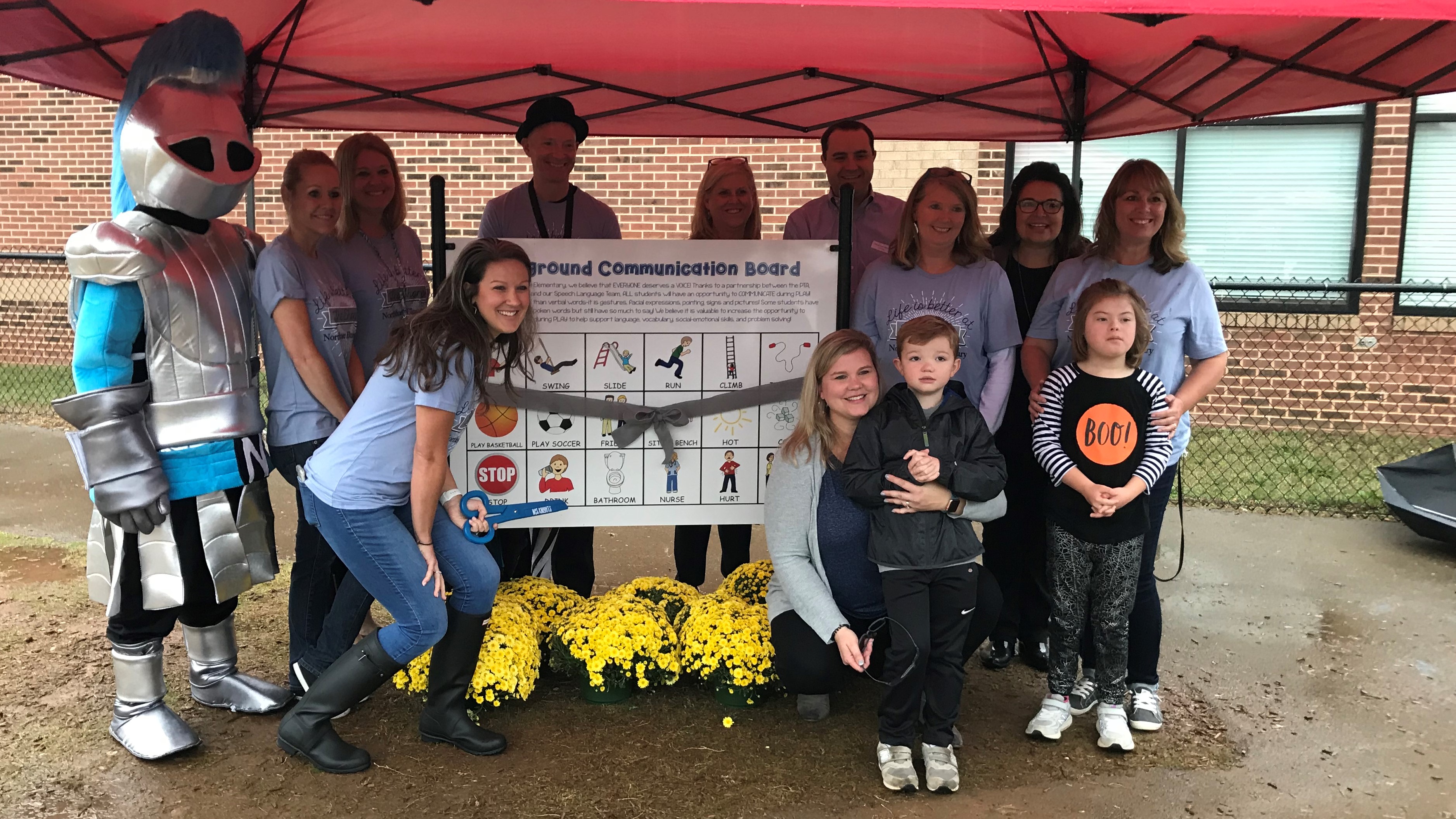Students and staff at Northshore Elementary prepare to cut the ribbon for a new Playground Communication Board on Wednesday, Oct. 30, 2019. 