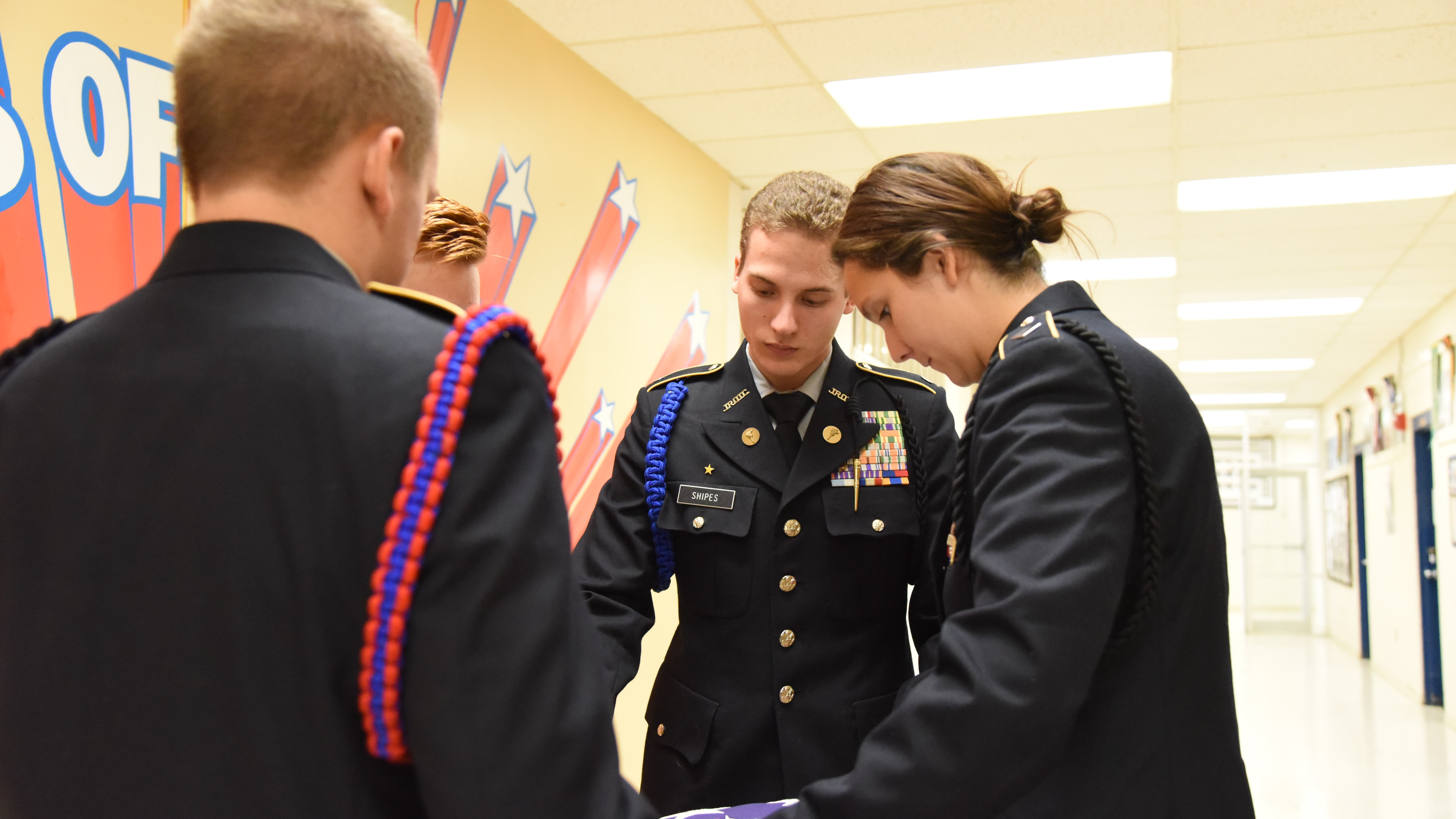 Justin Shipes, center, and other cadets from South-Doyle High School's JROTC fold a flag for retirement. The school's Cherokee Battalion is hoping to retire 1,000 flags next spring. 